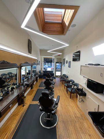Barber chairs beneath angular ceiling lights